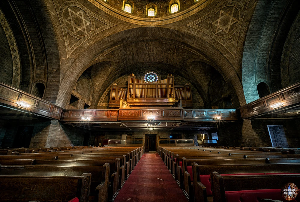 The grand sanctuary — pews intact, dome darkened, decades of dust.