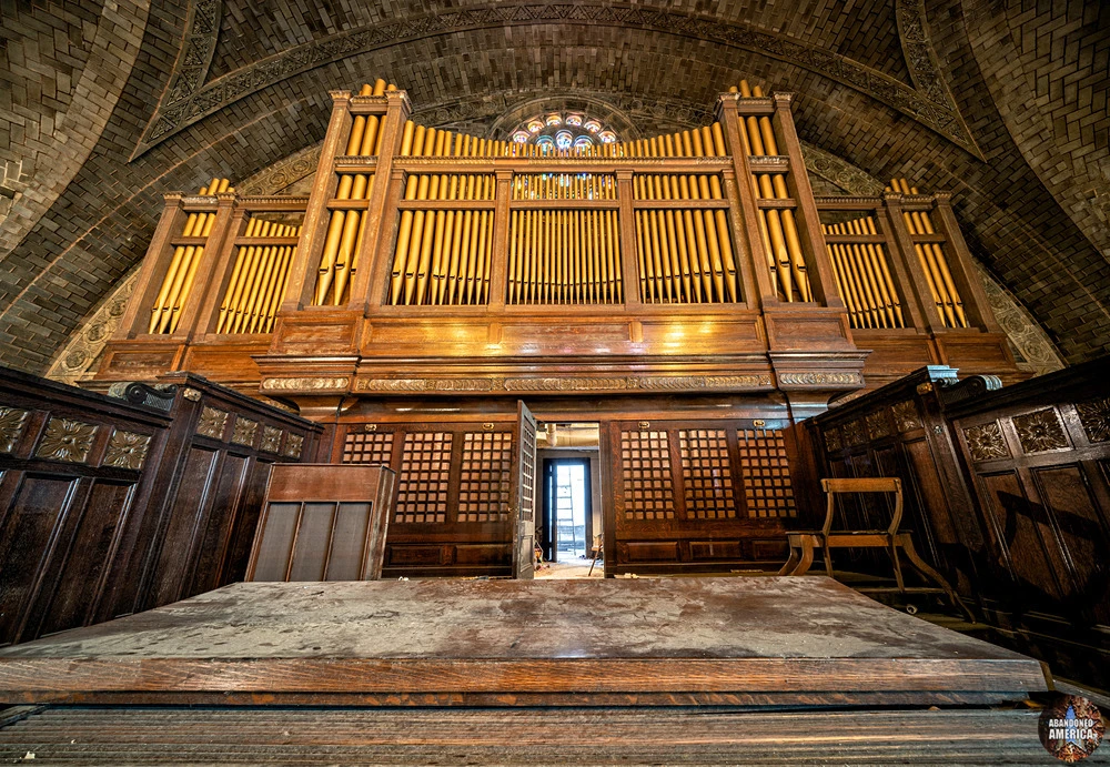 The pipe organ untouched, woodwork waiting to be reborn.